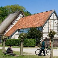 Veldwachter en landbouwer in traditionele klederdracht voor de kapel van Zepperen in het openluchtmuseum van Bokrijk, België
