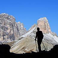 Bergwandelaar in silhouet tegen de berg Torre dei Scarperi / Schwabenalpenkopf, Dolomites, Parco Naturale Tre Cime, Dolomieten, Tirol, Italië