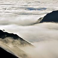 Zicht over de bergen gehuld in mist bij zonsopgang vanaf de Col du Tourmalet in de Pyreneeën, Frankrijk
